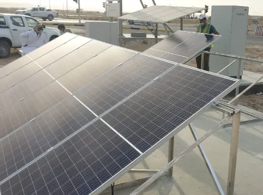 alt="Installation of solar panels in a desert environment for a sustainable energy project"